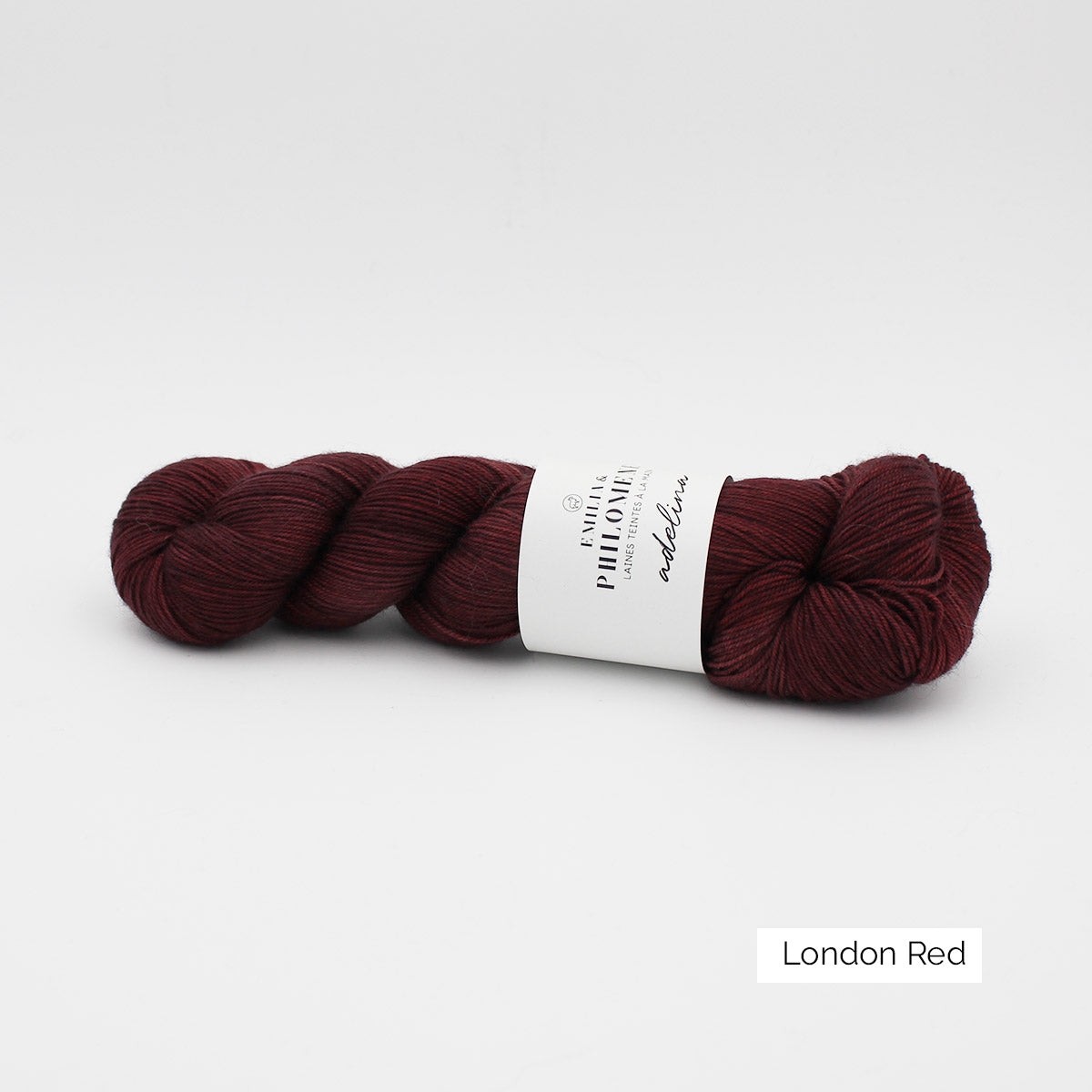 Un écheveau d'Adelina d'Emilia & Philomène coloris London Red (rouge foncé nuancé)