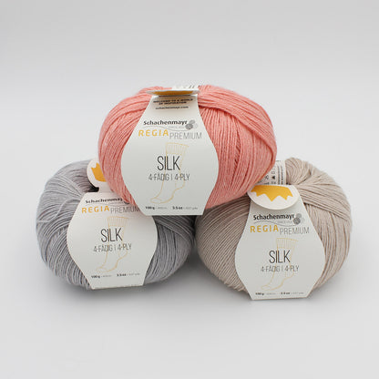 Trois pelotes de Regia Premium Silk dans des coloris assortis (gris clair, camel et abricot)