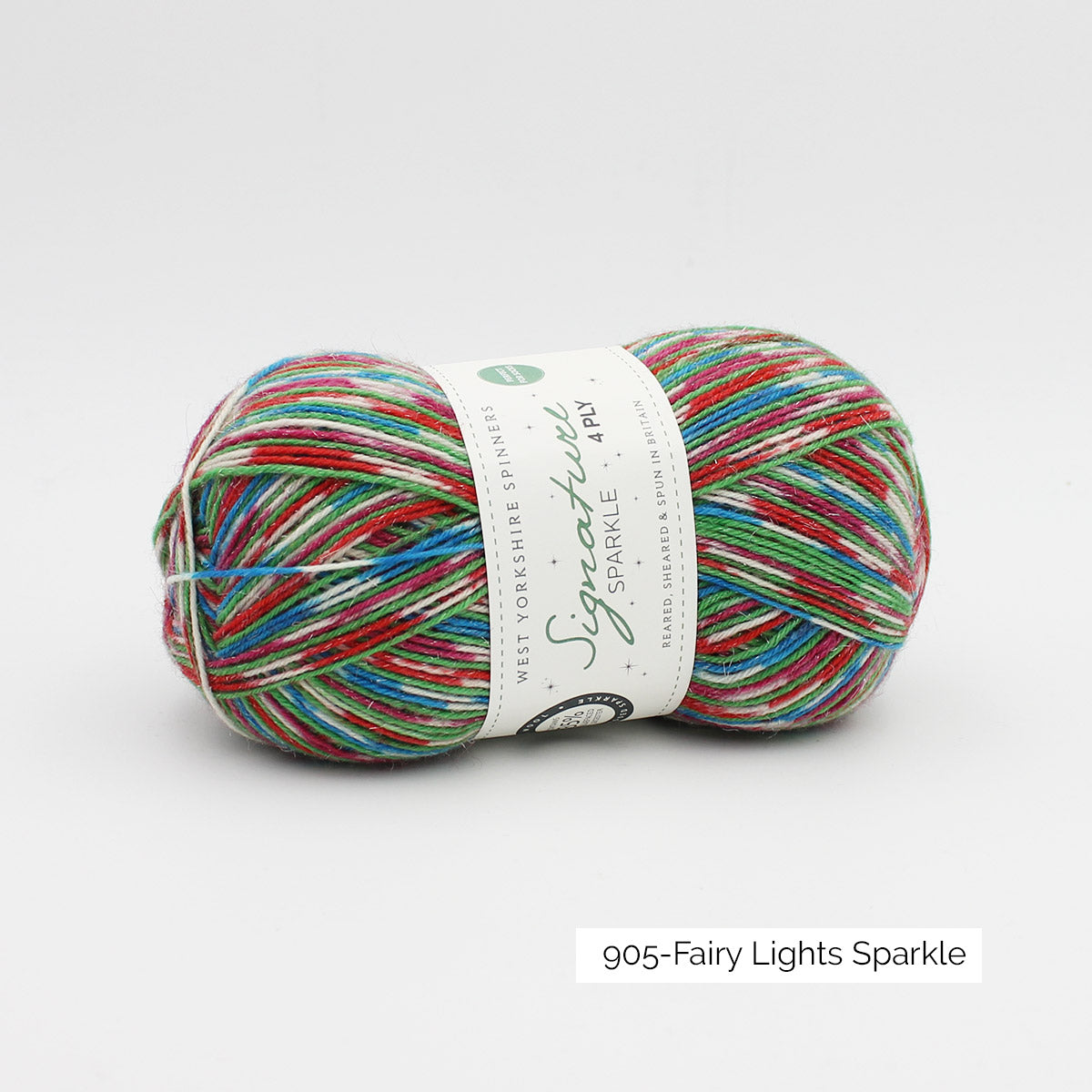 Une pelote de laine à chaussettes de la collection spéciale de Noël 2020 de West Yorkshire Spinners, coloris Fairy Lights Sparkle (création d'un motif dans les tons blancs, bleu azur, rouge et vert prairie)