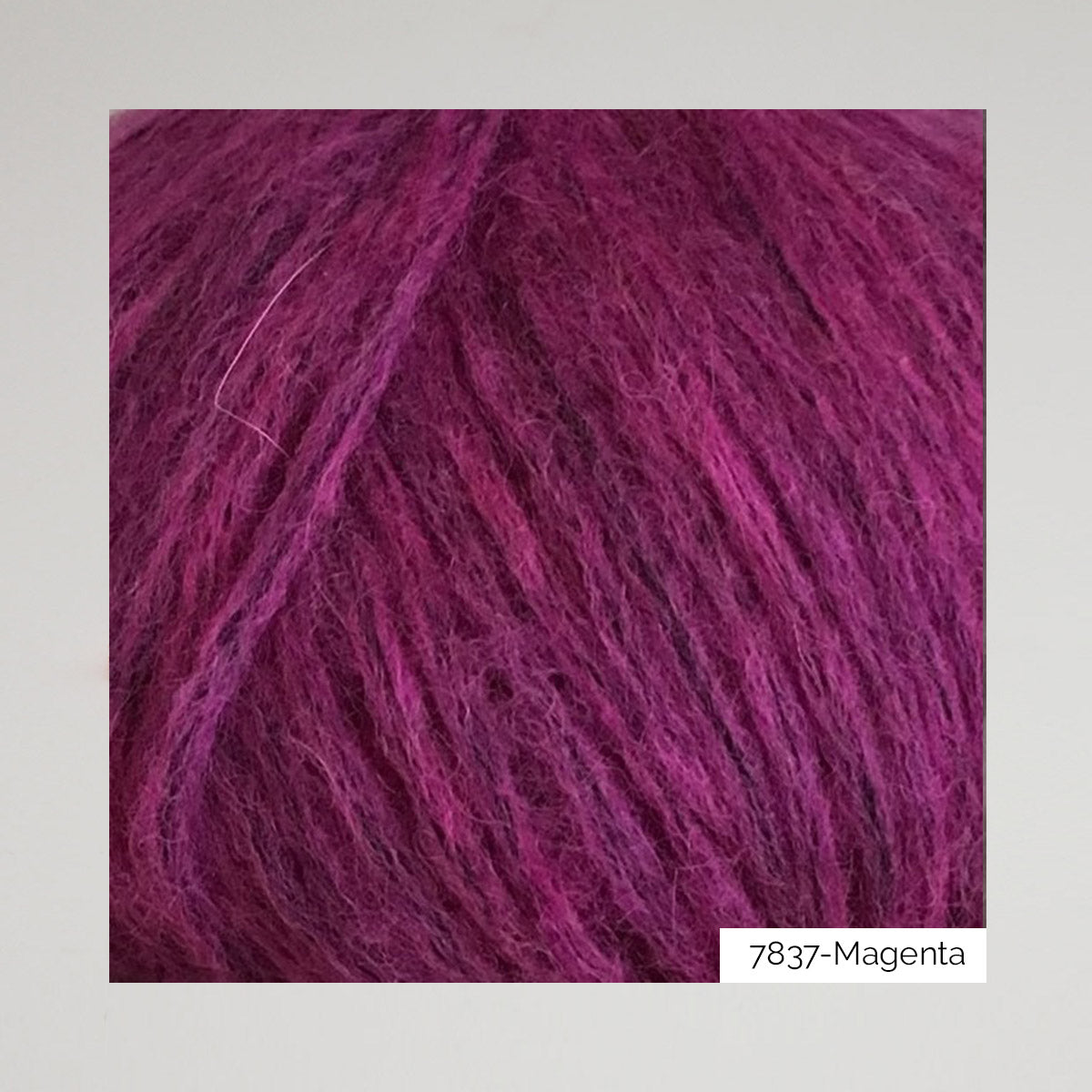 Texture et couleur d'une pelote de Snefnug de CaMaRose, alpaga et mérinos soufflé sur un filet de coton, coloris 7837 Magenta